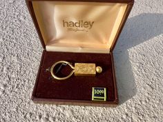 an open box with a gold keychain in it