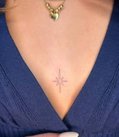 a woman's chest with a small star tattoo on the left side of her chest