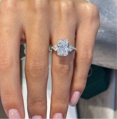 a close up of a person's hand with a diamond ring on their finger