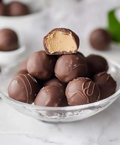 a glass bowl filled with chocolate covered truffles