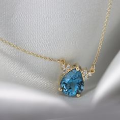 "Beautiful London Blue Topaz drop pendant with six sparkling diamonds to highlight the deep blue stone. Perfect mix of elegance and charm in one necklace. Features: *Center Stone: London blue Topaz pear cut 10x8 mm 2.46 ct *Secondary Stone: 6 diamonds 1.5-1.75 mm in diameter, VS-E. total 0.11 ct Handmade by an inspired jewelry artist team with decades of experience in the craft of jewelry making. Each gemstone, each diamond is carefully picked. Using only the finest raw materials and the highest Necklace Blue Stone, Blue Topaz Pendant Necklace For Wedding, Elegant Blue Topaz Necklace, Luxury Blue Topaz Necklace, Luxury Topaz Pendant Necklace, Light Blue Blue Topaz Pendant Necklace, London Blue Topaz Necklace, Blue Gemstone Necklace, Sapphire Eternity Ring