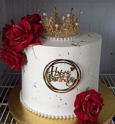 a white and gold birthday cake with red roses