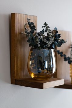 two vases with flowers are sitting on the shelf