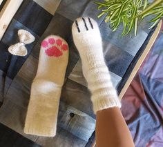 a woman's feet with pink and white socks next to a potted plant