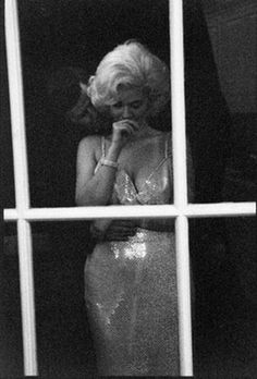 a woman in a sequin dress looks out the window at another man who is talking on his cell phone