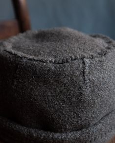 a gray hat sitting on top of a wooden chair