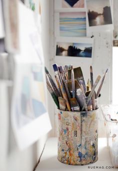 a cup filled with lots of art supplies