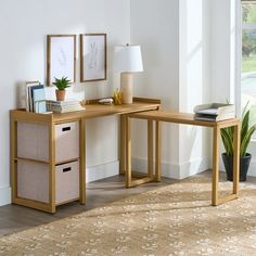 a wooden desk with two drawers in front of a window and a plant on the side