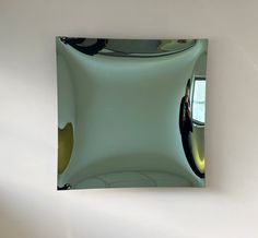 a square mirror reflecting the interior of a modern building with yellow and black accents on it