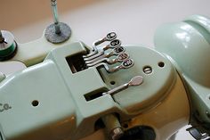 an old sewing machine with buttons and needles