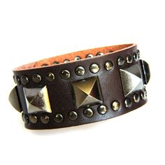 Genuine Leather Vintage style Bracelet that is Super Sexy This bracelet is designed with a 9 1/2 inch length piece of Brown genuine cowhide leather (1 1/4 inch wide) that is given Sexy Style with a center row of Antiqued Gray Pyramid Studs and a border of Rivet Studs.  It is finished with (2) sets of matching snaps for a wearable size variation of 7 1/2" & 8 1/4" Check out the rest of our Bling Collection at our eBay Store...The Lionz Bling. Thick Leather Bracelet, Spiky Bracelet, Punk Bracelets, Boho Leather Bracelet, Spike Bracelet, Diy Leather Bracelet, Brown Leather Bracelet, Brown Bracelet, Leather Cuff Bracelet