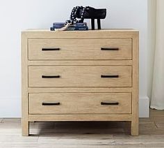 a wooden chest of drawers with books on top