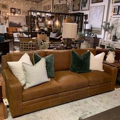 a living room filled with furniture and lots of pillows on top of it's couches