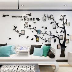 the living room is decorated in white and black with family photos on the tree wall