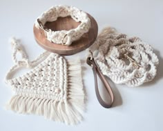 crocheted items are laid out on a white surface with a wooden bowl and spoon