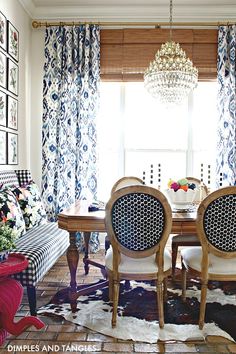 a dining room table with chairs and a chandelier hanging from the ceiling