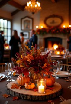 a table with candles and pumpkins on it in front of a fire place setting