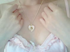 a woman wearing a necklace with a heart on it