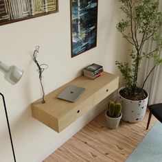 a desk with a laptop on it next to a potted plant