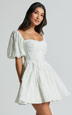 Celebrate the beauty of spring with our Esthela Mini Dress in Pale Mint. This enchanting piece features an embroidered square neck and short puff sleeves, giving it a sweet and feminine look. The corset detail cinches your waist for a flattering fit, while the flowy fit-and-flare silhouette adds a touch of romance to your outfit. Made from soft cotton fabric, this dress is perfect for both day-time parties and special occasions. Embrace your unique style and feel empowered in this gorgeous mini White Grad Dresses, White Dress Summer Short, White Dress Flowy, Flowy Dress Short, Cotton Dress Fabric, White Dresses Graduation, Dress Alterations, Short Puff Sleeve, Off White Dresses