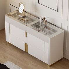 a bathroom vanity with two sinks and gold faucets on the top, in front of a white paneled wall