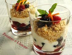 two glasses filled with dessert sitting on top of a table