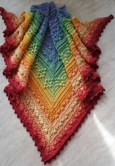 a multicolored crocheted blanket laying on top of a white countertop