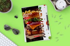 a cookbook sitting on top of a desk next to a keyboard and glasses,