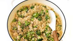 a skillet filled with rice and broccoli on top of a white counter