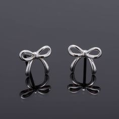 Pair of stud Earrings of delicate design in the form of a bow, made in Real 925 silver in a minimalist style, ideal gift for girl, teenager or woman. Material: 100% 925 Sterling Silver. Bolt size: 6mm x 10mm. Weight: 0.66 grams per pair. Tips for the care of your Silver Jewelry: * Keep your silver jewelry in a cool and dry place to avoid oxidation. * Avoid exposing them to water, perfume, and harsh chemicals. * Clean your Silver jewelry relatively frequently to maintain its shine and beauty. All Silver Earrings Aesthetic, Ribbon Earrings, Gift Bow, Water Perfume, Ear Jacket Earring, Silver Bow, Small Earrings Studs, Delicate Design, Bow Earrings