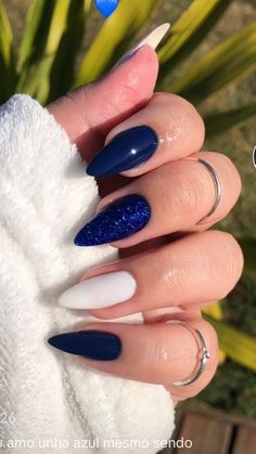 a woman with blue and white nail polishes on her nails, holding a towel