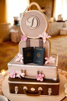 two suitcases stacked on top of each other with passport and flowers in the middle