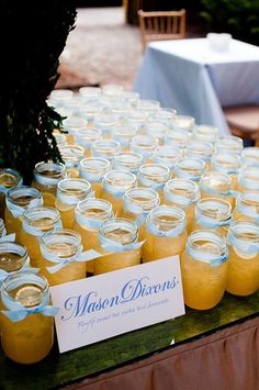 mason jars are lined up on a table for guests to sit down and enjoy their meal