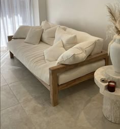 a living room with a couch, table and vase on the floor next to it