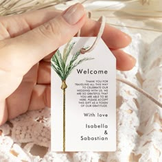 a person holding a welcome card in their left hand with a string attached to it