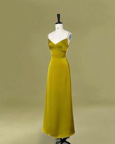 a mannequin is dressed in a yellow dress