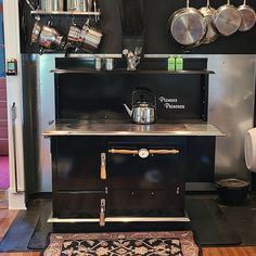 an old fashioned stove with pots and pans on it's shelves in a kitchen