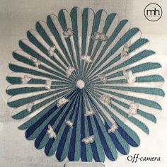 a large blue and white fan sitting on top of a table next to a wall