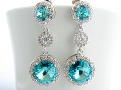 "Handmade Sterling Silver Earrings feature sparkly Light Turquoise Swarovski crystals that are set in frames designed and made exclusively for Estylo Jewelry. These beautiful earrings are made of Crystallized Elements drops that hang from Sterling post earrings with matching Turquoise Swarovski crystals surrounded by tiny clear Cubic Zirconia stones and round cubic zirconia connectors. They are perfect for a wedding or any other special occasion. They are gorgeous as focal point of your outfit. Blue Bling Jewelry For Wedding, Blue Bling Wedding Jewelry, Blue Rhinestone Crystal Earrings For Wedding, Elegant Turquoise Bridal Earrings For Wedding, Turquoise Earrings For Wedding, Light Blue Ocean, Bridal Dangle Earrings, Turquoise Bridesmaid, Blue Beach Wedding