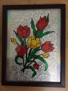 a glass window with flowers painted on it's side, hanging from the wall