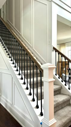 a staircase with white walls and black railings