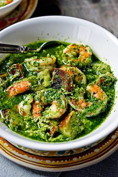 a white bowl filled with shrimp and pesto