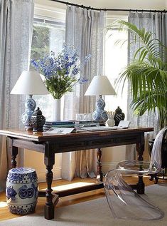 a living room filled with lots of furniture and flowers in vases on top of a table