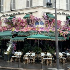 an outdoor cafe with tables and chairs covered in flowers