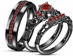 two wedding rings with red stones on them