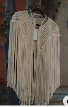 a white crocheted shawl hanging from a tree