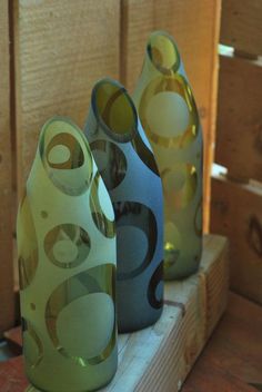 three vases sitting on top of a wooden shelf