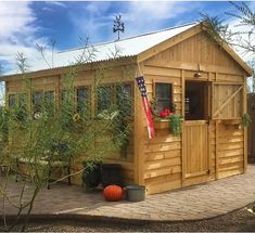 a small wooden shed sitting on top of a brick patio