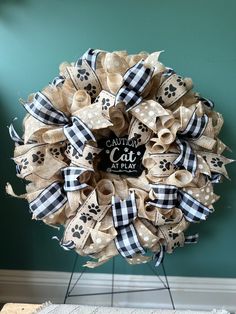 a dog's paw print wreath on a stand with the words cat at play written on it