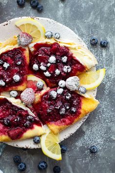 lemon and blueberry crepes with powdered sugar on top